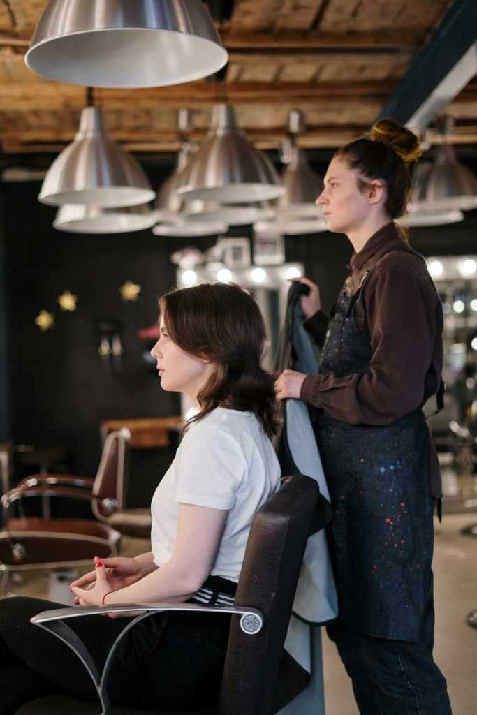 Hair stylist working with client in a cozy, modern hair salon.