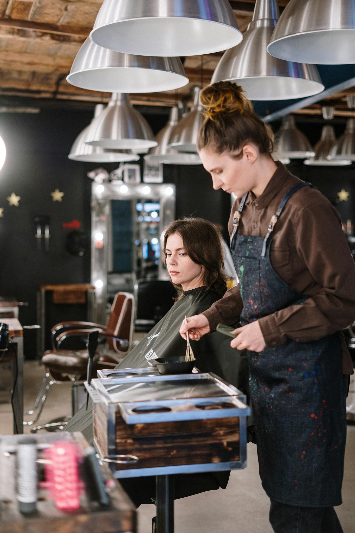 A hair stylist expertly colors a client's hair in a stylish salon setting.