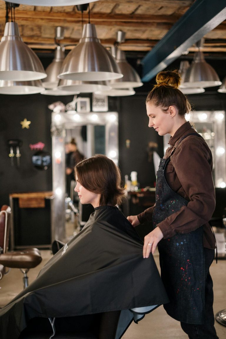 Hair stylist preparing for a haircut in a modern, well-lit salon.